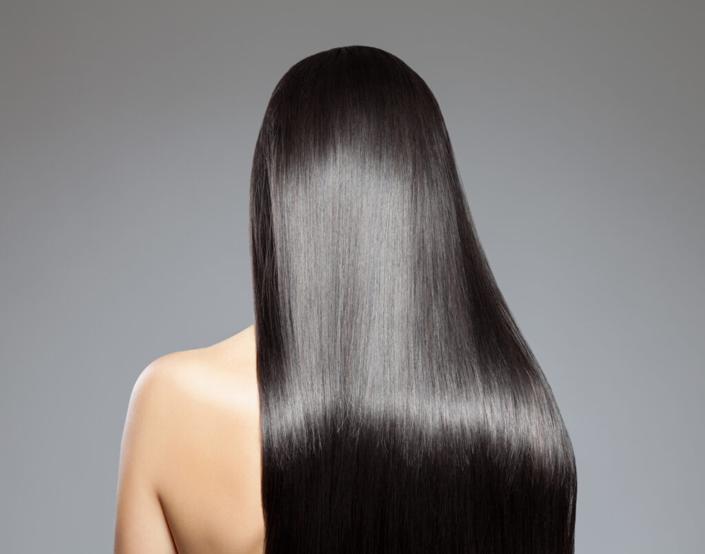 Back view of a woman with long straight hair at Lea Salon Studios